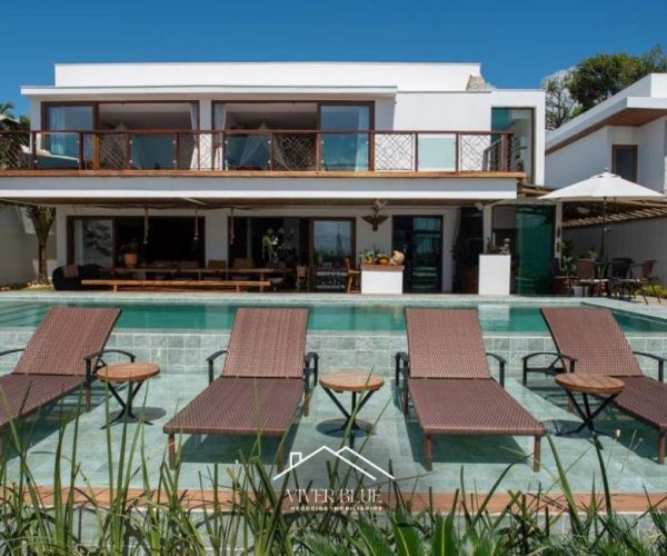 Fachada da casa com arquitetura moderna, varanda ampla e vista privilegiada para a área da piscina