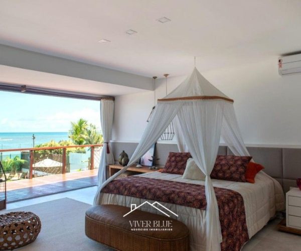 Suíte master com varanda e vista, cama com dossel e atmosfera de conforto e exclusividade.