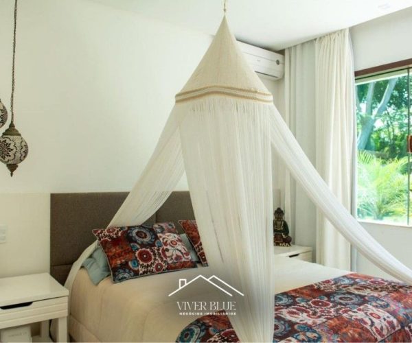 Quarto aconchegante com cama com dossel, decoração leve e iluminação natural.