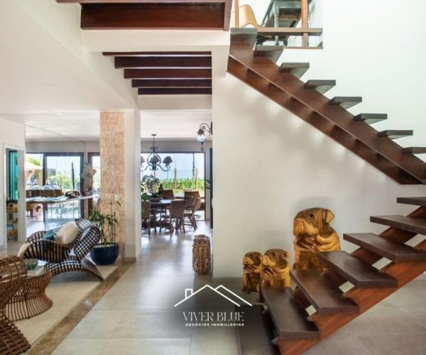 Ambiente interno com escada moderna, integração de espaços e design arquitetônico sofisticado.